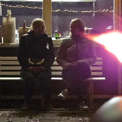 Twee spelers overleggen buiten op een bankje in de avond