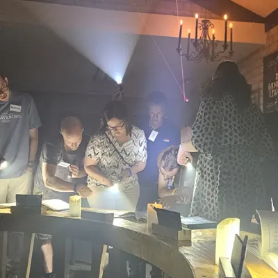 Spelers buigen zich over hun aanwijzingen terwijl rook door de zaal hangt